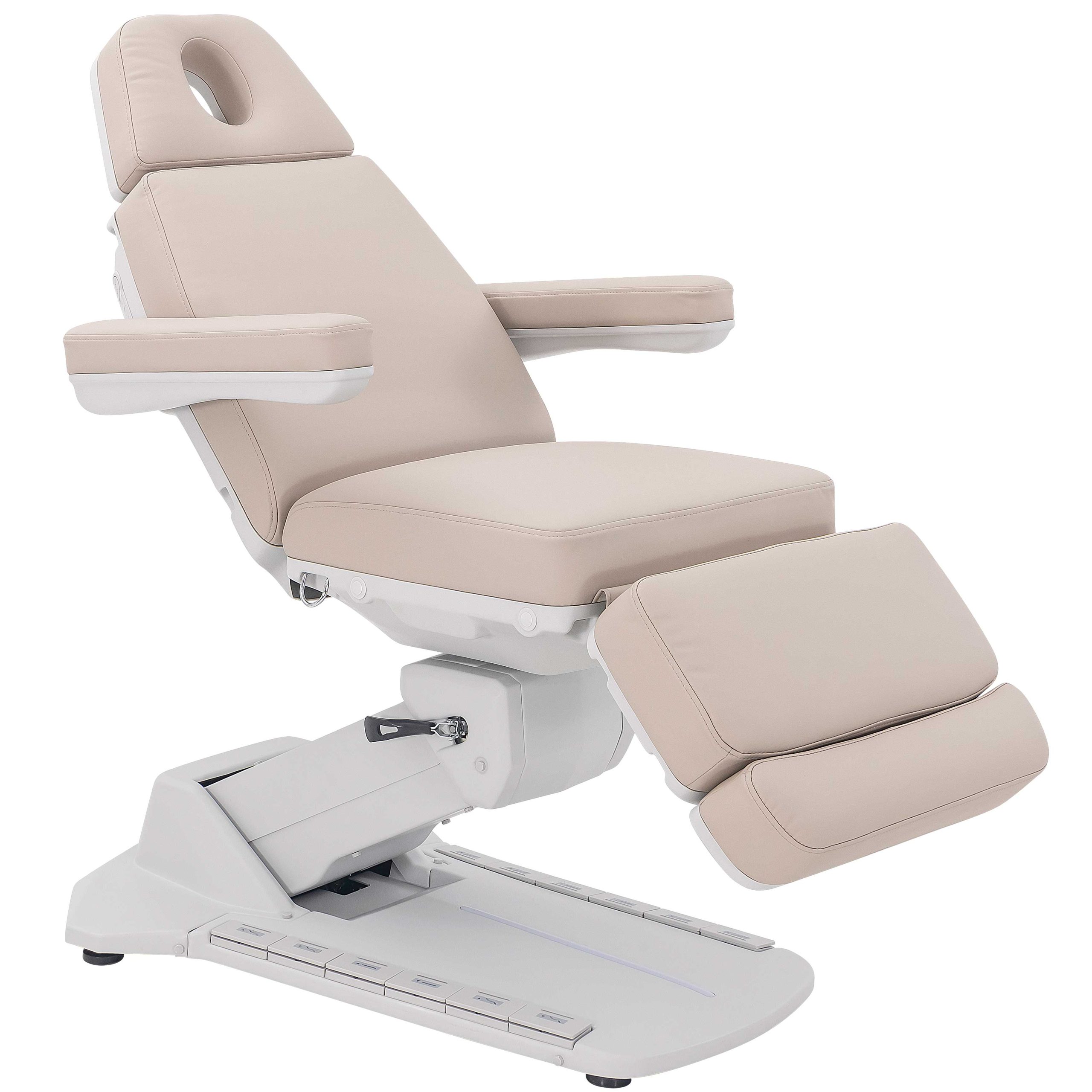 Beige reclining chair with padded headrest, armrests, and leg supports on a white base, seen from the side.