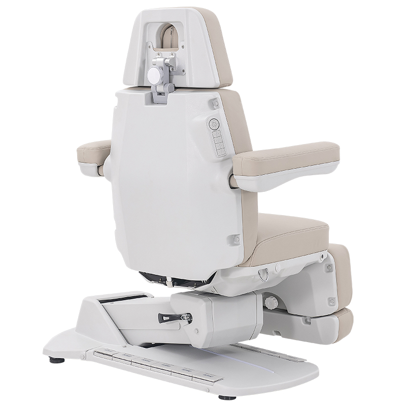 Medical examination chair with beige cushions and adjustable armrests on a white base, designed to position patients during exams.